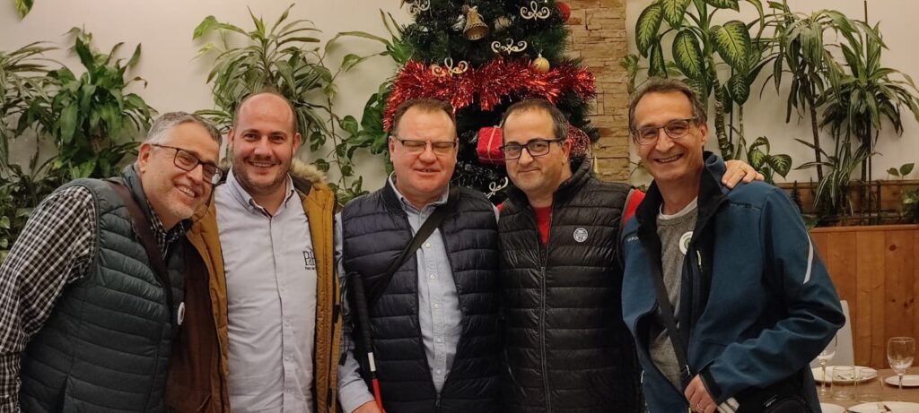 Amigable foto de grupo junto a árbol de Navidad.
