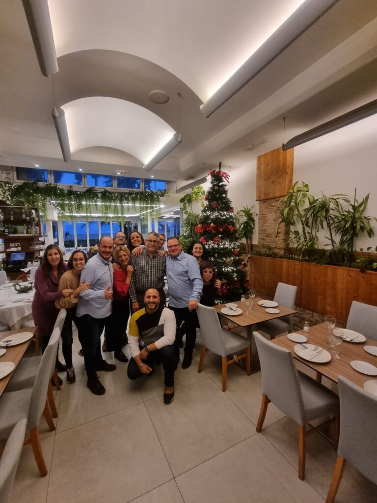 Grupo de participantes junto a un árbol de Navidad